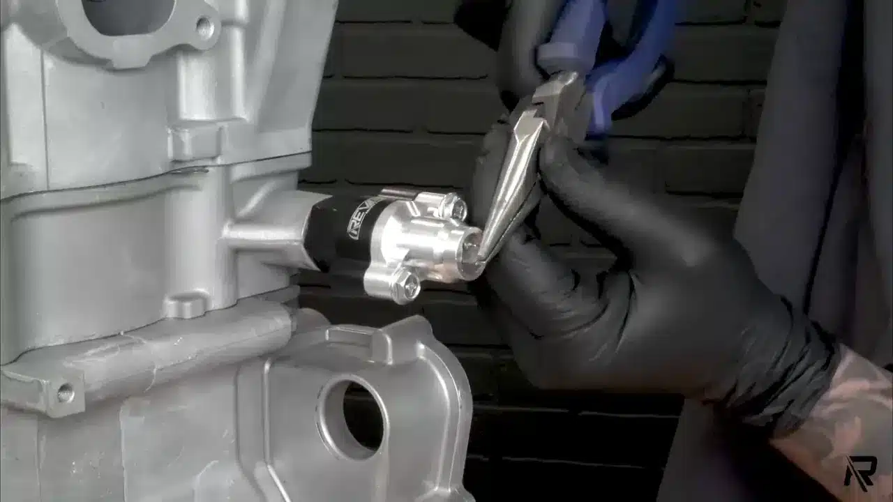 REV6 using needle-nose plyers working on Cam Chain Tensioner
