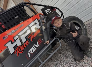 Zeppelin pointing at the REV6 Powersports logo on his RZR 570 machine as he gets ready for the upcoming race